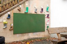 Tafel Außenbereich Wandtafel im Außenbereich mit Gummistiefeln an der Wand