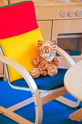 Ein Kuscheltier Löwe sitzt auf einem Stuhl