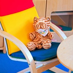 Ein Kuscheltier Löwe sitzt auf einem Stuhl