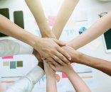 ein Team Hände kommen aus alles Richtungen und stapeln sich aufeinander