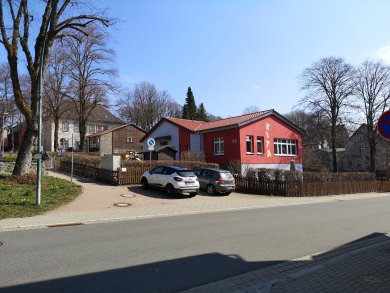 Marktstraße, an der Straße stehen Autos, mit Blick auf die Kita